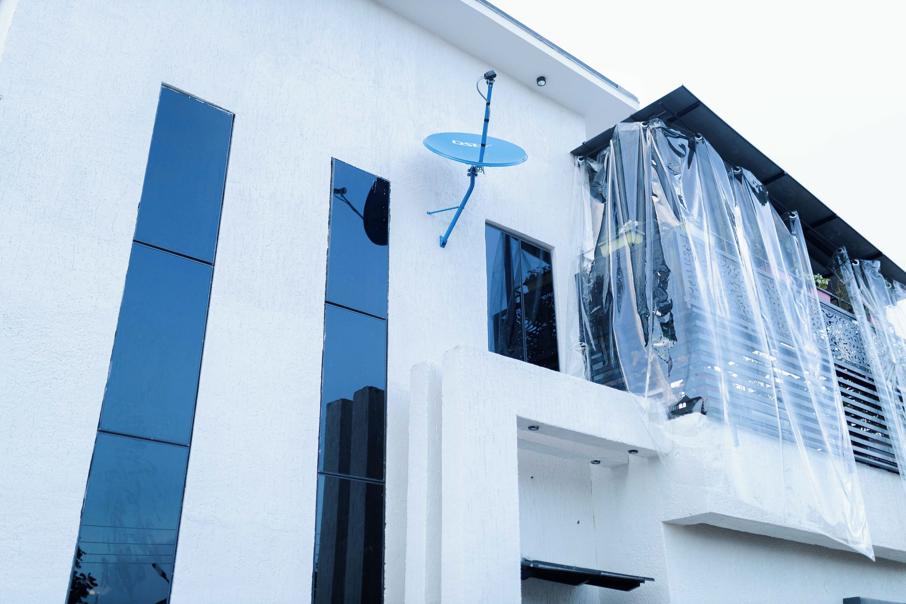 Un edificio con ventanas amplias y una antena parabólica.