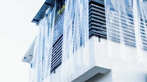 Un bâtiment moderne doté de grandes fenêtres et d’une façade blanche.