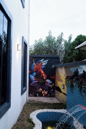 A building with a mural of a colorful fish on the side. - Leemas 2 Bedroom Duplex  (Jos)