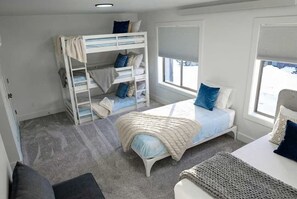 A bedroom with bunk beds, a single bed, and a view of the outdoors. - Teewinot Townhome - Yellowstone, Targhee, Tetons (Victor)