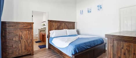A bedroom with a wooden bed, a nightstand, a wardrobe, and a ceiling fan.