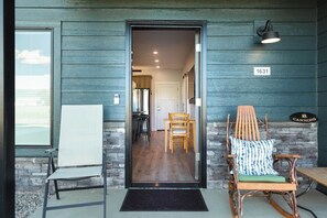 A wooden exterior with a door leading to a kitchen area, a stone wall, and a sign reading 'CANNONS'. - Teton Hideout - Sauna, AC, Garage (Driggs)