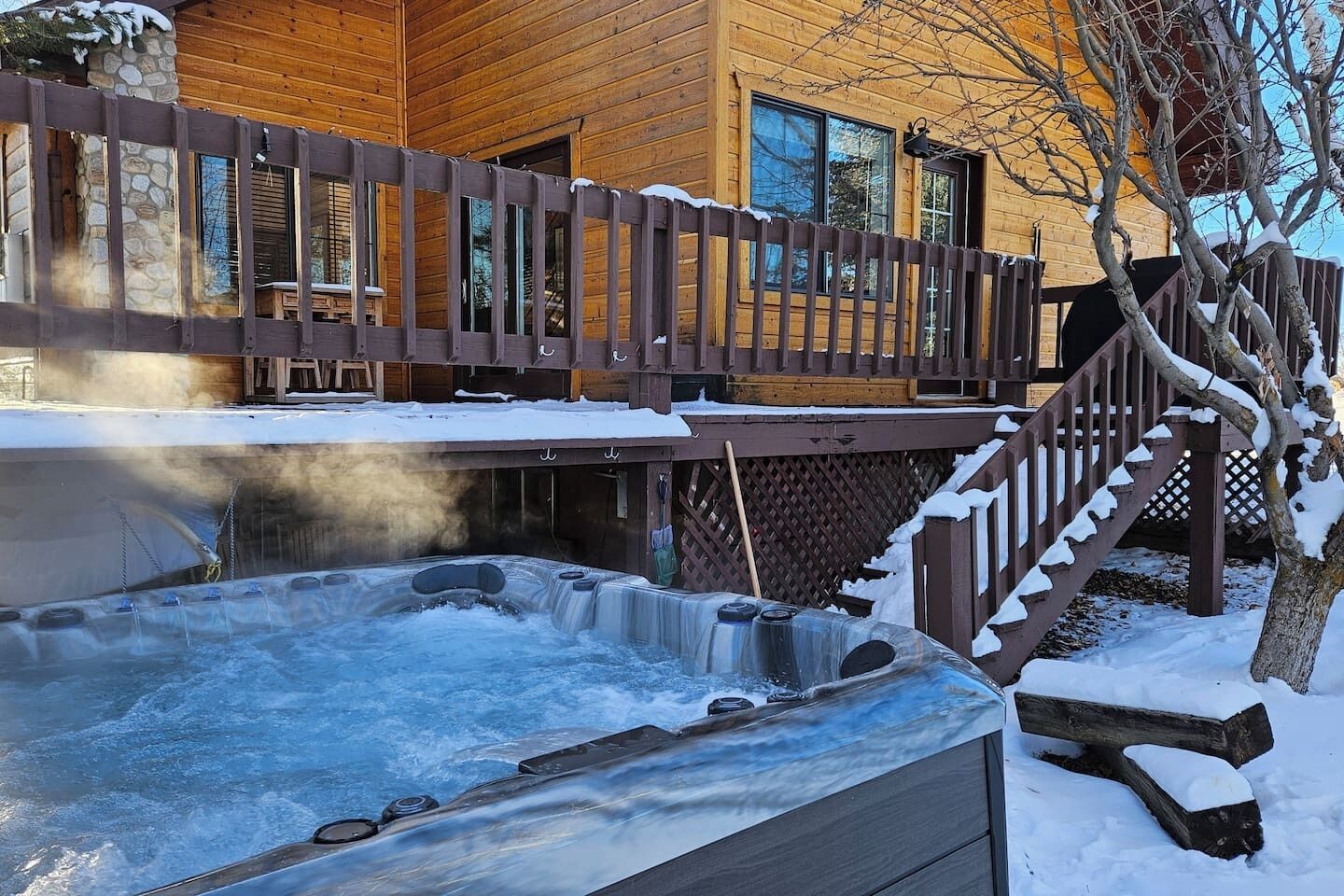 A wooden cabin with a hot tub and a wooden deck.