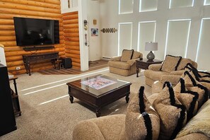 A log cabin interior with a television, sofa, and coffee table. - Grizzly Home on Ski Hill Road, Targhee shuttle (Driggs)