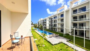 A modern hotel with a pool, outdoor seating, and a clear view of the pool area. - Walking 2 Beaches, Dining, Shop, Fun, Nightlife (Punta Cana)