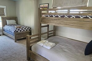 Ein Stockbett mit einem Bett unten und einem darüber. An der Wand über dem Bett hängt ein Schild.