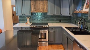 A modern kitchen with grey cabinets, a stainless steel stove, and a dishwasher. - Sleeps 10! Updated Townhome Off Ski Hill Rd (Driggs)