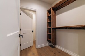 A hallway with a white door, wooden flooring, and a built-in shelving unit. - White Pine Lodge in Teton Valley (Driggs)