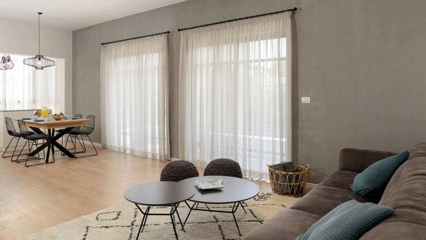 Un salon moderne avec un coin repas, comprenant un canapé, une table basse et une table à manger avec des chaises.