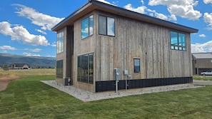 Ein modernes, zweistöckiges Holzhaus mit großen Fenstern und einer Flachdach.