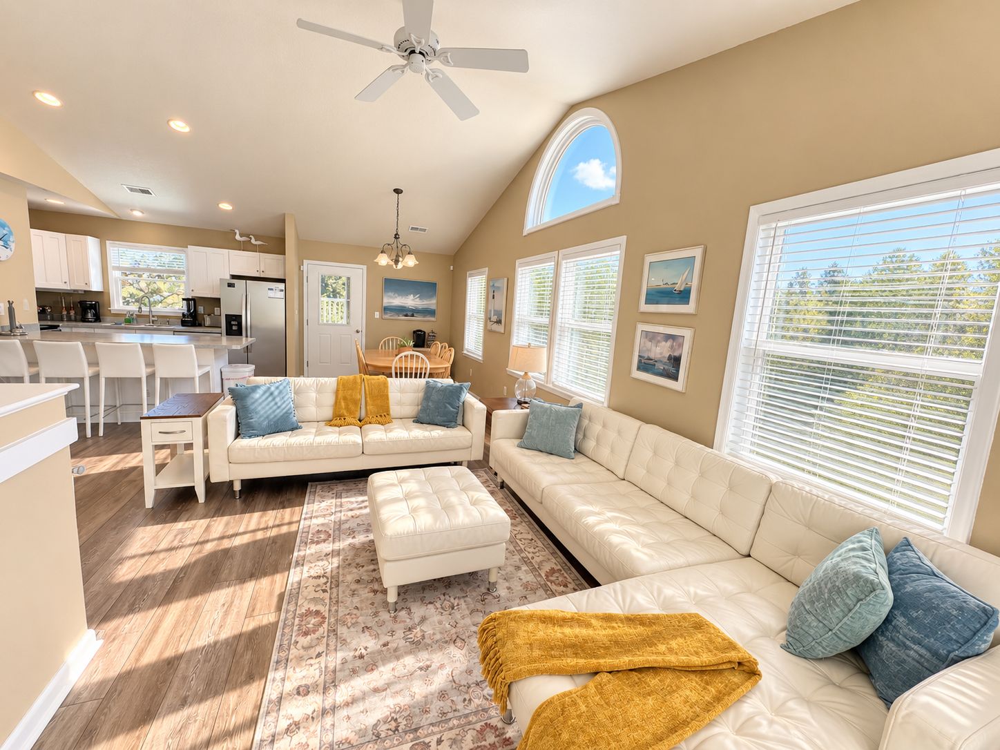 A spacious living area with a sofa, ottoman, and a dining table.