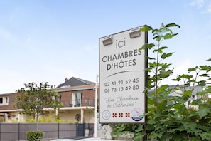 A sign for 'Les Chambres de Catherine' hotel with contact numbers and a logo. - Bed and Breakfast 'Chambre 2' with Shared Terrace, Shared Garden and Wi-Fi (Merville-Franceville-Plage)