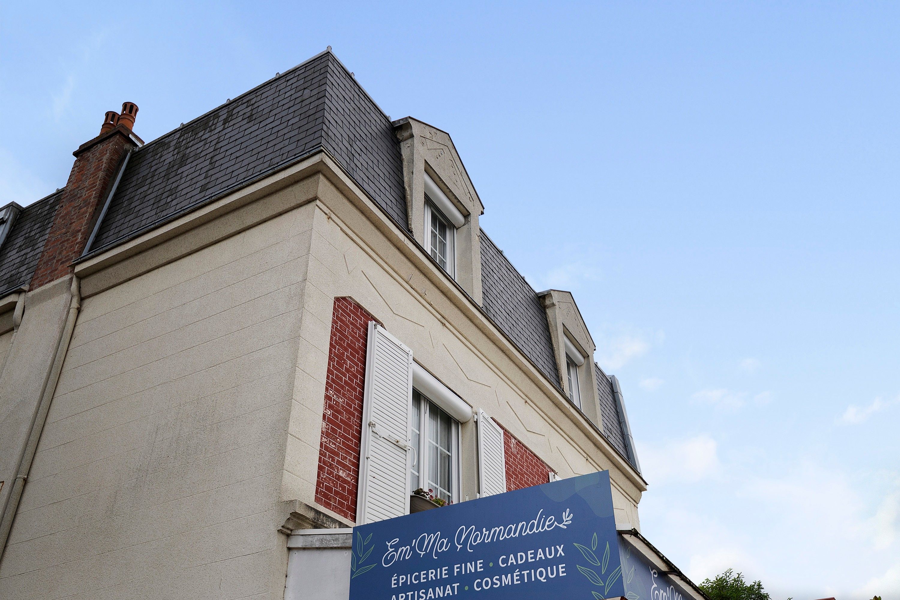 Un bâtiment sur lequel est apposée une enseigne indiquant : « Épicerie fine, cadeaux, articles d’artisanat, produits de beauté ».