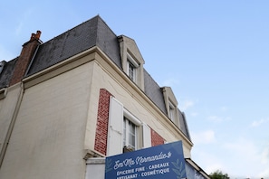 A building with a signboard advertising 'Épicerie Fine, Cadeaux, Artisanat, Cosmétique.'