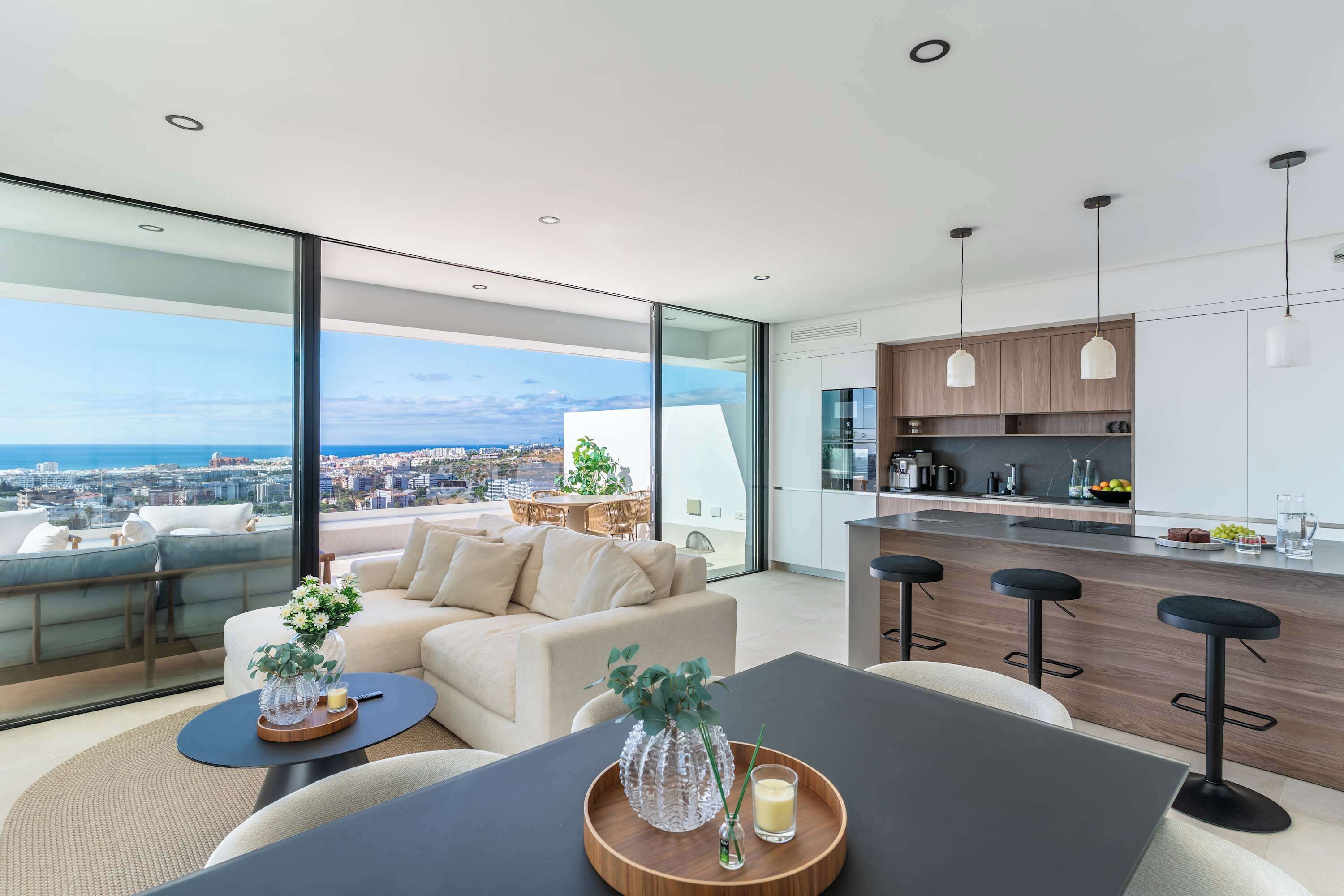 Een modern appartement met een groot balkon, een eethoek en een keuken.