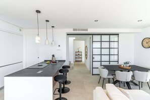 A modern kitchen with a central island, bar stools, and pendant lighting. - Mirador Estepona Hills 15 | Pool & Private Jacuzzi (Estepona)