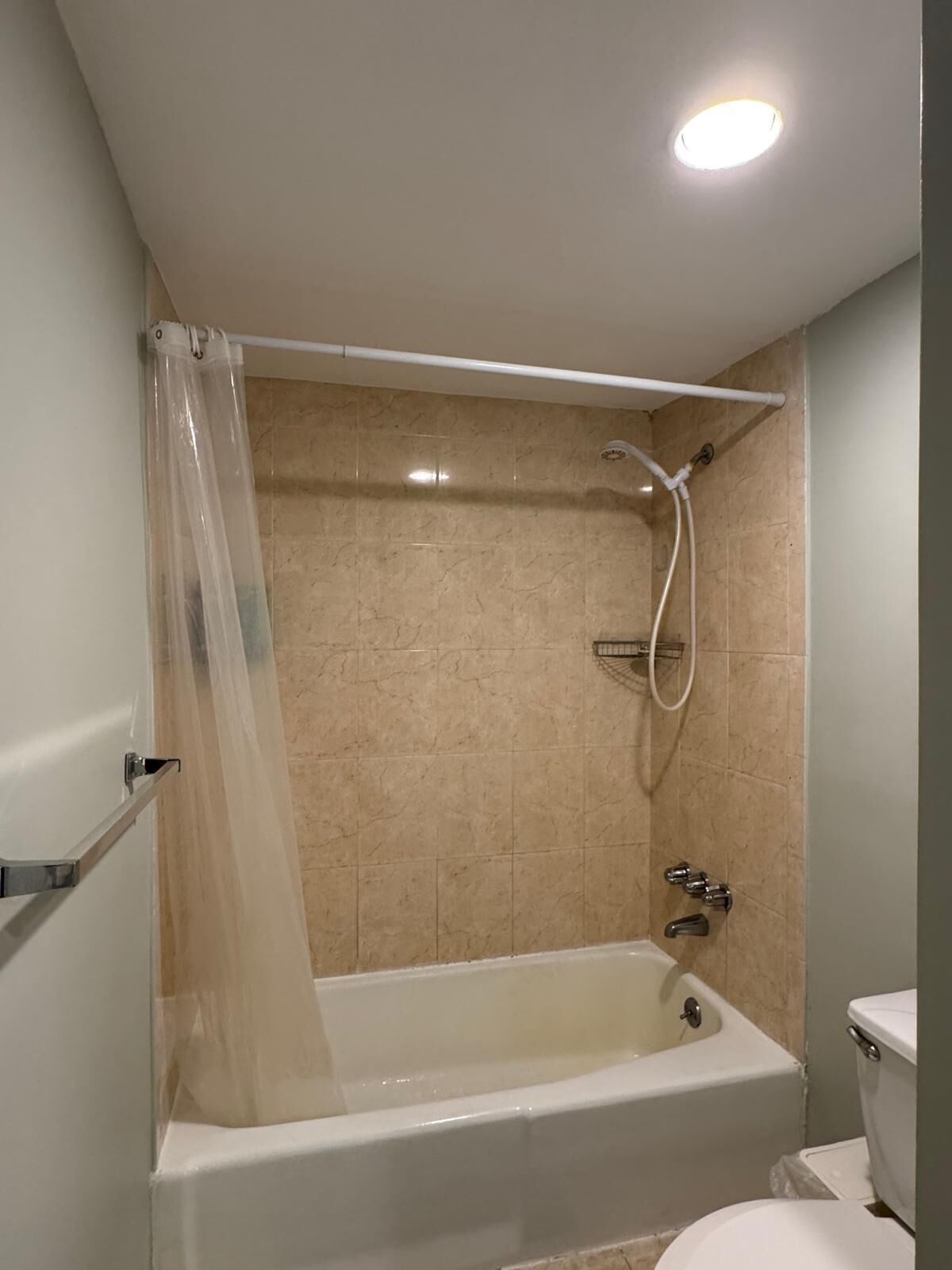 A bathroom with a bathtub, shower, and toilet.