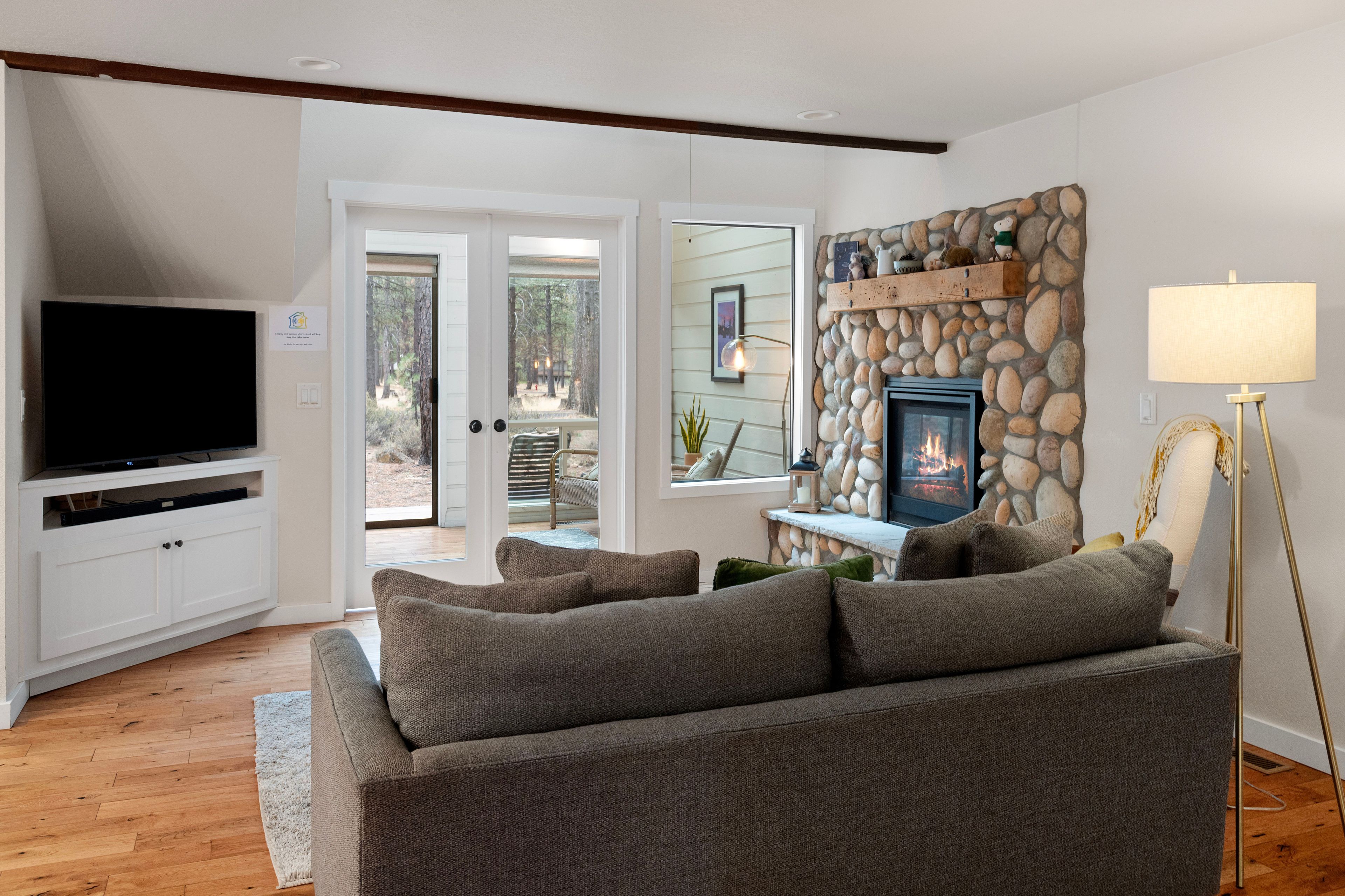 A living room with a television, sofa, fireplace, and a lamp.