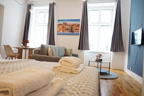 Ein Hotelzimmer mit Bett, Sofa, Schreibtisch und Fernseher.