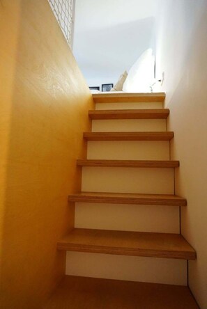 Eine Treppe mit Holzboden und einer gelben Wand.