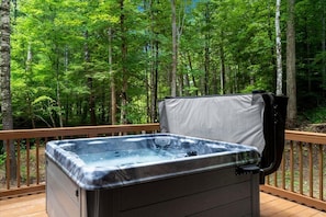 A hot tub on a wooden deck surrounded by a forest. - Nightfall Cabin - Creekside Getaway by Waterfall (Wolfe County)