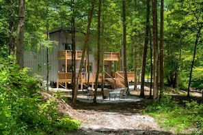 A cabin with a deck and outdoor seating area surrounded by trees. - Nightfall Cabin - Creekside Getaway by Waterfall (Wolfe County)