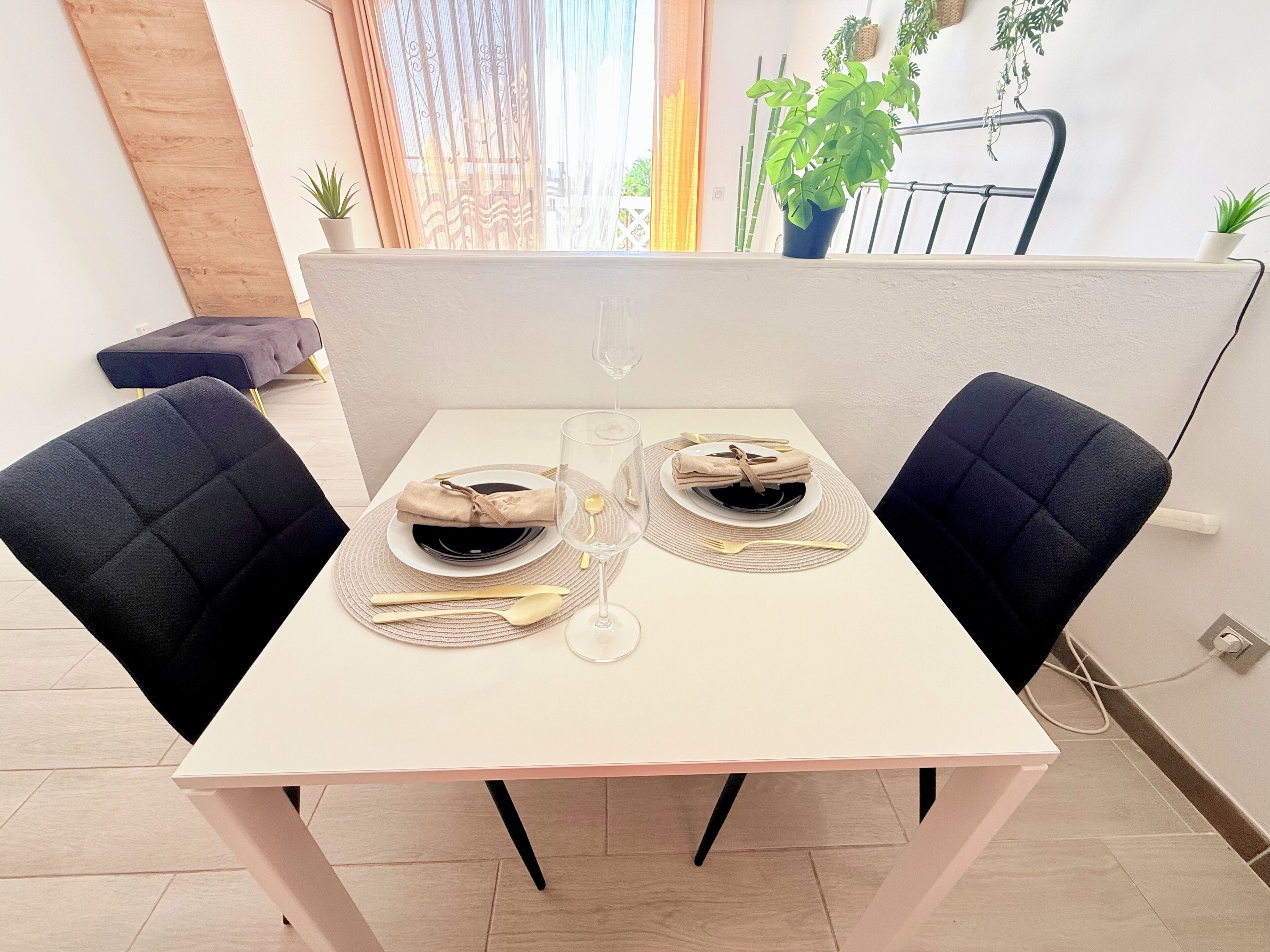 Een eettafel gedekt met borden, bestek en een glas.