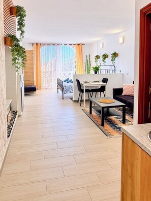 Un espace de vie moderne comprenant un coin repas, un canapé et un comptoir de cuisine.