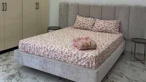 A bedroom with a bed, a wardrobe, and a small table. - Villa Younes (Djerba Midun)