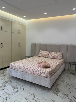 Ein Schlafzimmer mit Bett, Kleiderschrank und einem kleinen Tisch.