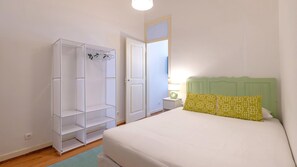 A bedroom with a bed, a wardrobe, and a nightstand. - Arroios City Base | 2BR & Workspace by LovelyStay (Lisboa)