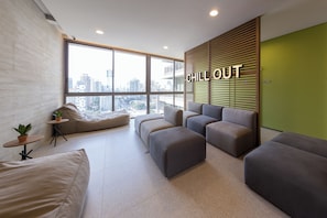 Ein stilvoller Lounge-Bereich mit Stadtblick, einem 'CHILL OUT'-Schild und einer grünen Akzentwand.
