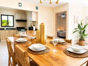 A dining area with a wooden table set for four, surrounded by woven chairs. - 3-Bedroom Villa Near the Beaches / Pool / Gym / Near Downtown Punta Cana (Punta Cana)