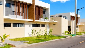 A modern two-story building with a flat roof, large windows, and a clean, minimalist design. - 3-Bedroom Villa Near the Beaches / Pool / Gym / Near Downtown Punta Cana (Punta Cana)