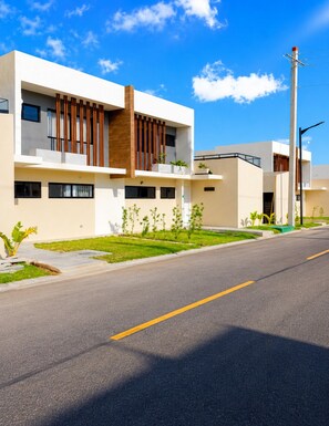 A modern two-story building with a flat roof, large windows, and a clean, minimalist design. - 3-Bedroom Villa Near the Beaches / Pool / Gym / Near Downtown Punta Cana (Punta Cana)