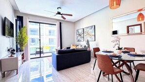 A modern living room with a sofa, dining table, chairs, and artwork. - Walk 2 Fun, Beaches, Dining, Shopping, Nightlife (Punta Cana)