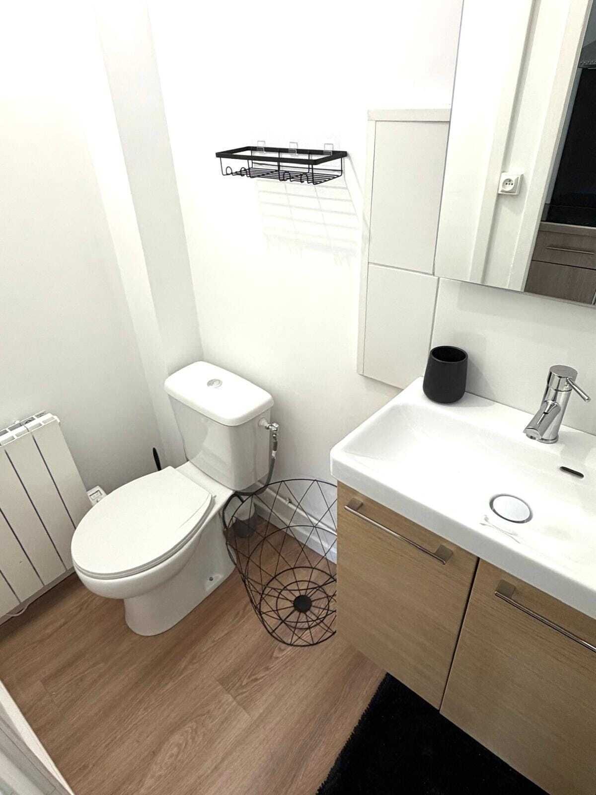 Un baño pequeño con inodoro, lavamanos y espejo.
