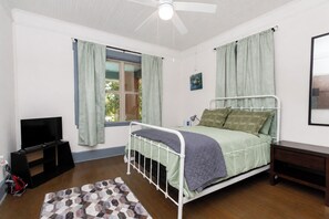 A bedroom with a bed, a window with curtains, a ceiling fan, and a television. - Charming 3BR/2BA Retreat West Downtown Pensacola (Pensacola)