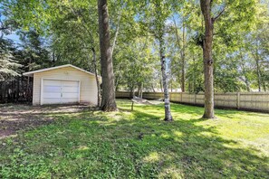 Ein Wohnhaus mit Garage, einem eingezäunten Garten und einer Hängematte.