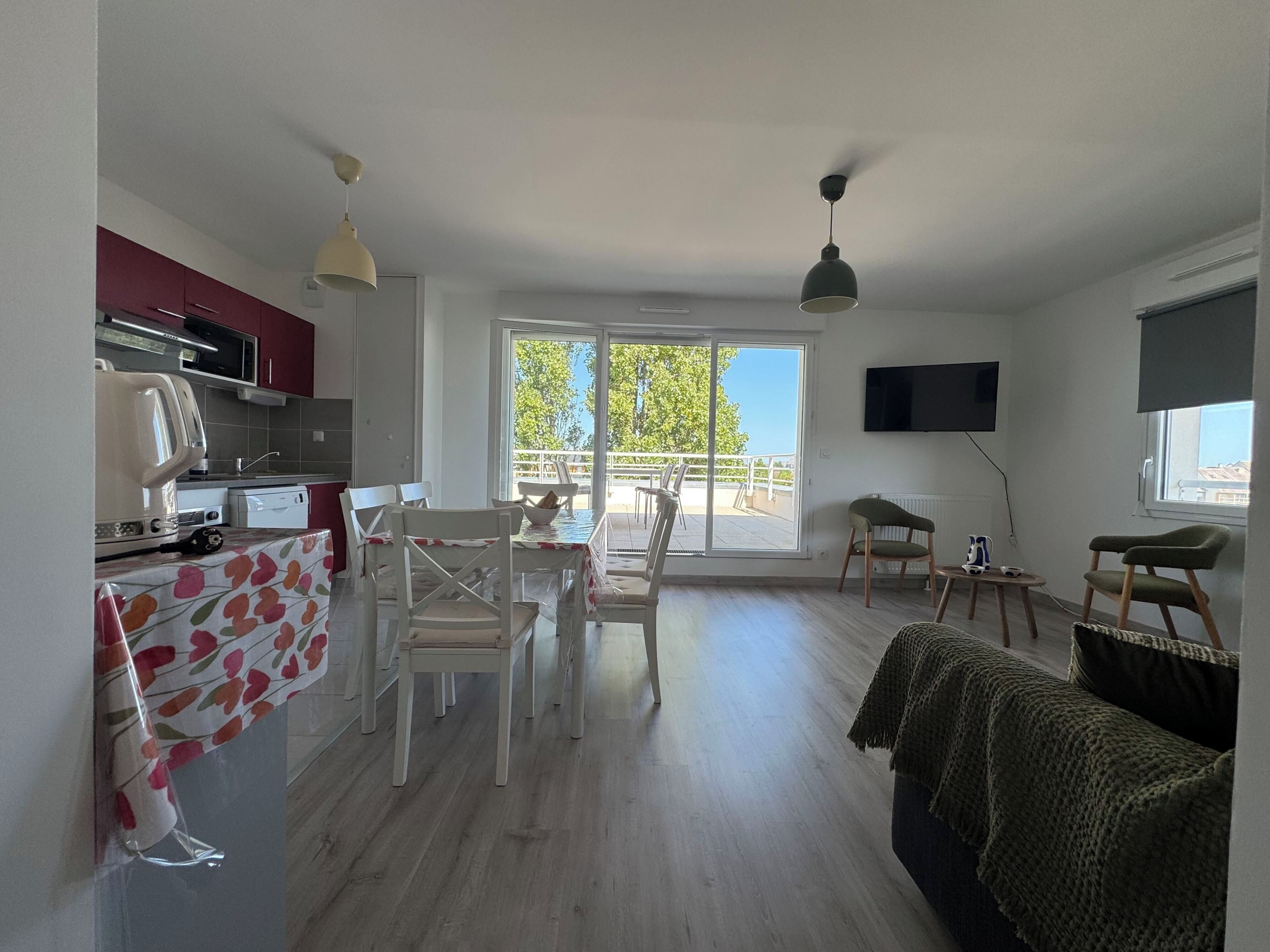 Un salon moderne comprenant un coin repas, une cuisine et un balcon avec vue.