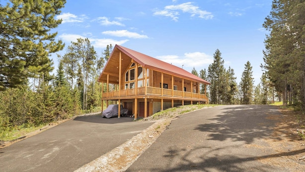 Eine Holzhütte mit Balkon, umgeben von Bäumen.
