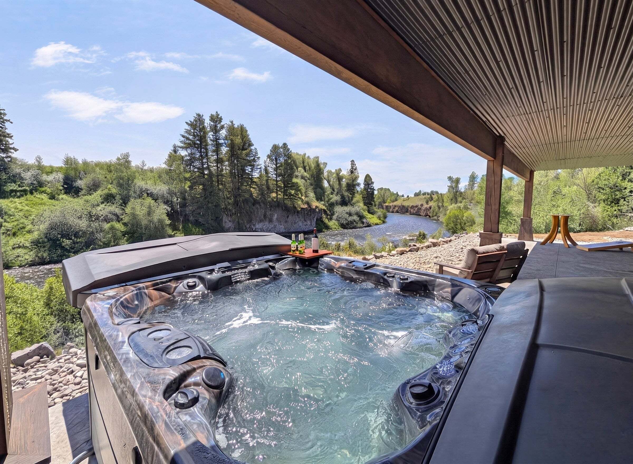 A hot tub with a river view, outdoor seating, and a covered area.