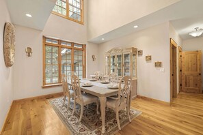 A dining room with a wooden table, chairs, and a decorative cabinet. - Alpine Ascent (Alpine)