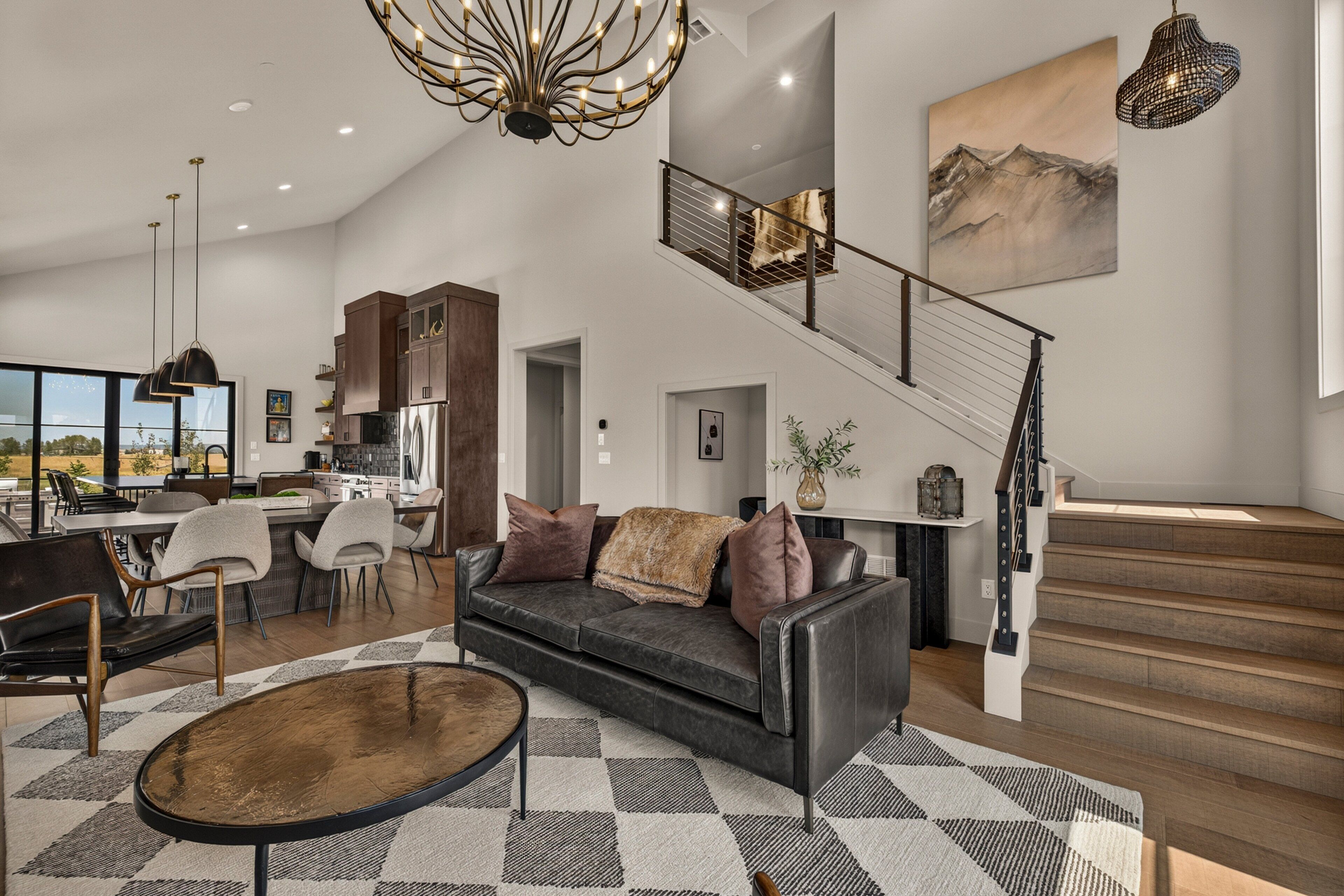 A modern living room with a sofa, coffee table, and a staircase leading to an upper level.