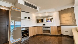 Eine moderne Küche mit Backofen, einem großen Spiegel und Blick auf den Ozean.