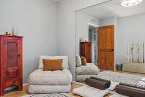 A bedroom with a bed, a wooden wardrobe, a mirror, and a door. - Santa Fe Oasis With Three Primary Suites and Garden Nooks, Can't Miss (Santa Fe)