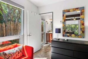 A modern interior with a red sofa, a black dresser, and a colorful mirror. - Santa Fe Oasis With Three Primary Suites and Garden Nooks, Can't Miss (Santa Fe)