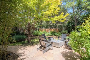 An outdoor patio area with a fire pit, seating, and surrounding greenery. - Santa Fe Oasis With Three Primary Suites and Garden Nooks, Can't Miss (Santa Fe)