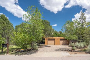 A residential property with a garage, a mailbox, and a clear sky. - Santa Fe Oasis With Three Primary Suites and Garden Nooks, Can't Miss (Santa Fe)