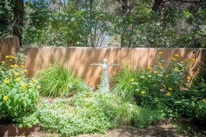 A garden with a statue, various plants, and a fence. - Santa Fe Oasis With Three Primary Suites and Garden Nooks, Can't Miss (Santa Fe)
